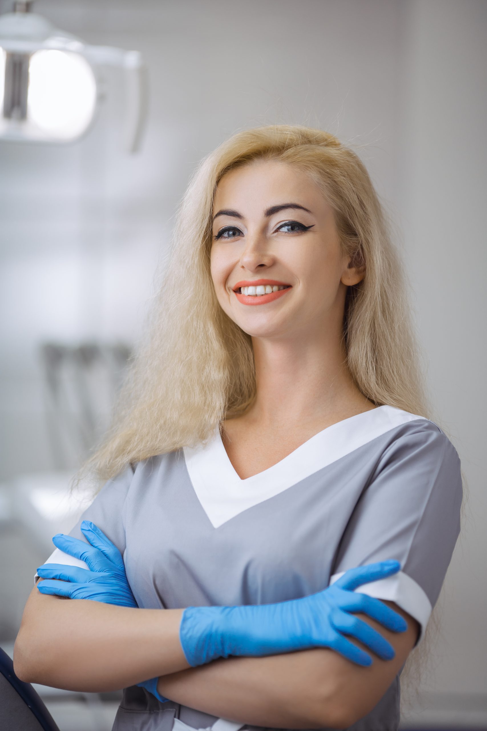 Portrait of female dentist smiling with arms crossed in dental clinic